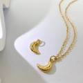 Detail eines goldenen Croissant-Anhängers mit realistischer Textur an einer Gliederkette - Goldenes Croissant-Stil (G-Stil)
