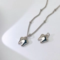 Detailansicht des spiegelpolierten Zahnanhängers und der feinen Halskette in Silber - Silberner Zahn Stil (O-Stil)