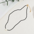 Collana minimalista con perline nere, pendente con lettera M bianca e chiusura oro - Stile Spinello Nero (XL-299-9)