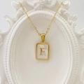Goldene Halskette mit quadratischem Muschel-Anhänger und Buchstabe F auf einem Rahmen - Buchstabe F / Weiß
