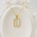 Goldene Edelstahl-Halskette mit quadratischem Muschel-Anhänger und Buchstaben-Detail J - Buchstabe J / Weiß