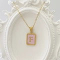 Goldene Edelstahlkette mit quadratischem rosa Muschel-Anhänger und Buchstabe F - Buchstabe F / Rosa