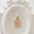 Goldene Halskette mit rechteckigem Anhänger, rosa Muscheltextur und dem Buchstaben K - Buchstabe K / Rosa