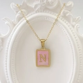 Goldene Edelstahlkette mit einem rechteckigen rosa Anhänger und dem Buchstaben N - Buchstabe N / Rosa