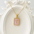 Goldene Edelstahlkette mit einem rosa rechteckigen Anhänger mit dem Buchstaben T - Buchstabe T / Rosa
