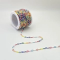 Detail of colorful enamel paperclip chain on white spool for DIY jewelry making projects - Style A