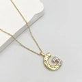 Elegant gold G-letter pendant necklace with bicolor cubic zirconia inlay on a grey surface - Letter G
