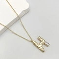 Golden H letter pendant necklace featuring lava texture and white cubic zirconia stones - Letter H