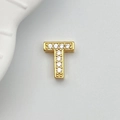Macro detail of gold-plated letter T charm with ten sparkling white zircon stones - Letter T