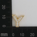 Macro view of gold plated Y-shaped charm with white cubic zirconia on measurement scale - Letter Y