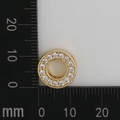 Macro shot of gold pendant with white zircon on a millimeter scale showing 12mm size - Letter O