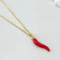 Close-up of bright red chili pepper pendant with golden fine link chain on stone decor - Red Chili Style