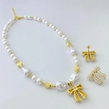 Détail de l'ensemble collier et boucles d'oreilles nœud en perles avec cœurs dorés - Style B Ensemble