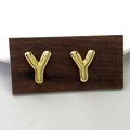 Minimalist polished golden metal letter Y stud earrings on a natural wood stand - Gold Y