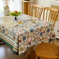 Vintage floral tablecloth in cream with dark blue and yellow patterns on wooden table - Jacquard Bellflower with Green Border / 140-100