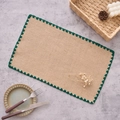 Detail of jute placemat with dark green crochet scalloped edges on a grey textured surface - 30x45cm / Green Scalloped Edge