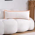 Detail of white lumbar pillow with orange pom-pom fringe on a textured sofa - Orange Scalloped Embroidery