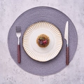Modern PP round braided placemat with vintage ceramic plate and striped border detail - Pp Gray Flat Woven Round Placemat 38 / 2-Piece Set