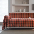 Housse de canapé à carreaux rouge rouille avec pompons sur un canapé moderne - 140x180 / Orange Vif Carreaux