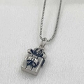 Detailed close-up of antique silver gift box pendant with bow on white satin fabric - Silver