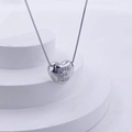 Macro detail of silver heart pendant with letter E crystal inlay on box chain - Silver E