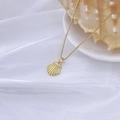 Detail einer goldenen Muschel-Halskette auf weißem Satin-Stoff mit Box-Kette - Stil H