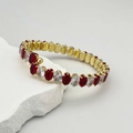 Détail d'un bracelet élastique doré avec cristaux ovales rouges et blancs sur pierre - Rouge & Blanc