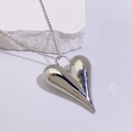 Macro shot of polished silver heart pendant necklace on a natural white stone base - Large Heart Pendant (Style B) / Style B Silver