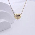 Polished gold heart pendant necklace featuring an X design with sparkling crystals - Gold X