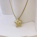 Goldene Stern-Halskette mit Zirkonia-Buchstabe T auf einem eleganten weißen Sockel - Gold T