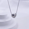 Polished silver heart pendant necklace with crystal letter J on white geometric stand - Silver J