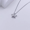 Sternförmige Silberkette mit diamantbesetztem S-Anhänger auf weißen minimalistischen Blöcken - Silber S-Form
