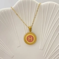 Collana con ciondolo a lettera H in smalto rosa e bordo dorato su vassoio bianco - Lettera H / Rosa