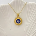 Collana dorata con ciondolo in smalto blu e iniziale G su un vassoio a conchiglia - Lettera G / Blu