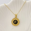 Elegante collana dorata con pendente rotondo nero lettera 'F' e bordi radianti dettagliati - Lettera F / Nero