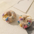Macro shot of colorful woven yarn hoop earrings with golden metal base for autumn style - Champagne Plush Hoop