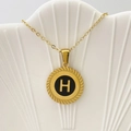 Collana dorata con ciondolo tondo nero e lettera H in oro con bordo intrecciato - Lettera H / Nero