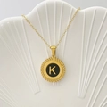 Elegante collana con ciondolo tondo dorato con smalto nero e dettaglio lettera K - Lettera K / Nero
