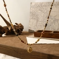 Vintage natural stone beaded necklace with sunset tones and oval pendant on wood - Caramel Necklace
