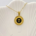Elegante collana con pendente a moneta d'oro con centro nero e dettaglio della lettera T - Lettera T / Nero