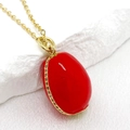 Macro shot of bright red Easter egg pendant with 14K gold plating and cubic zirconia - Red