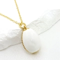 Detailed close-up of 14K gold-plated oval white pendant with elegant wavy metal edge - White