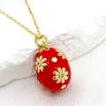 Detail of red enamel Easter egg pendant with golden embossed flowers and white dots - Red