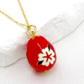 Detailed close-up of a 14K gold-plated Easter egg pendant with red enamel and floral design - Red