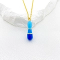 Golden necklace with blue enamel tiered drop pendant on white silk background - Letter I Style