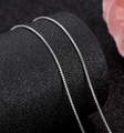 Polished silver box chain necklace with delicate square links on black pedestal - Box Chain / Silver