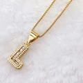 Detailed macro view of iced out gold capital L letter pendant with pavé cubic zirconia - Gold L