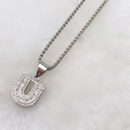Detailed close-up of zircon-encrusted silver letter U pendant with round and baguette stones - Silver U
