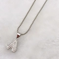 Detail of silver letter A necklace pendant featuring baguette and round cubic zirconia - Silver A
