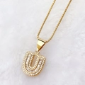 Luxury gold letter U pendant necklace with baguette-cut zircons on plush white backdrop - Gold U